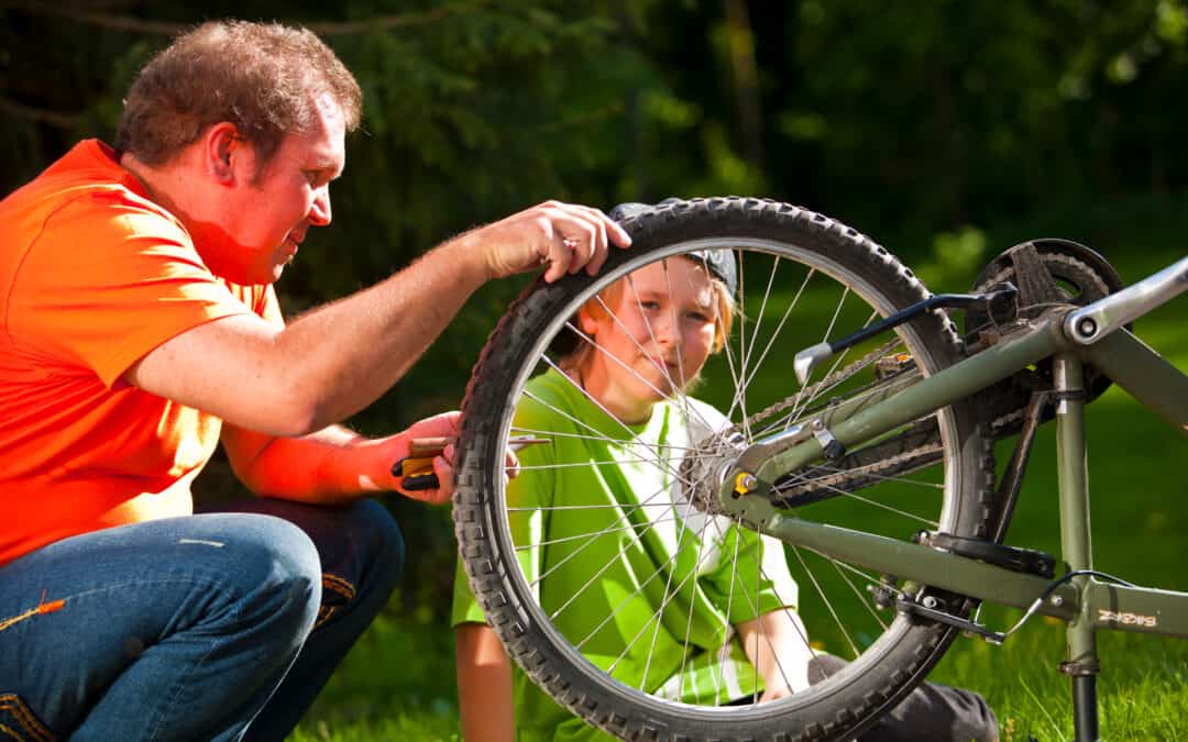 Mies ja poika korjaavat pyörää