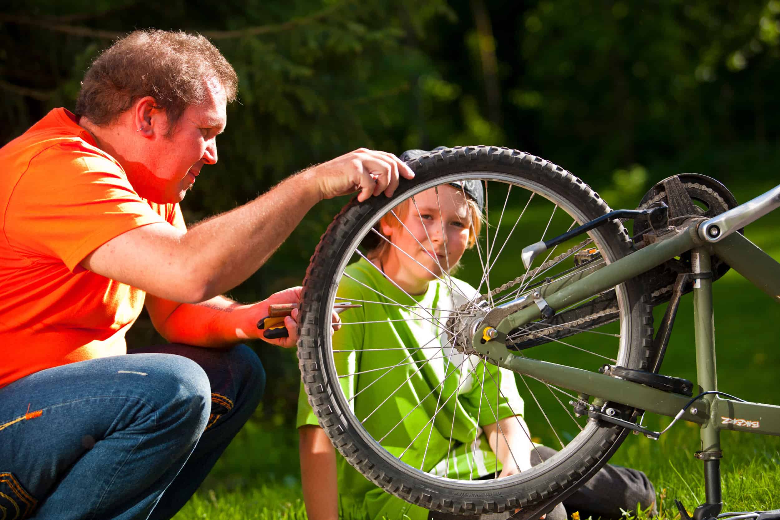 Mies ja poika korjaavat pyörää