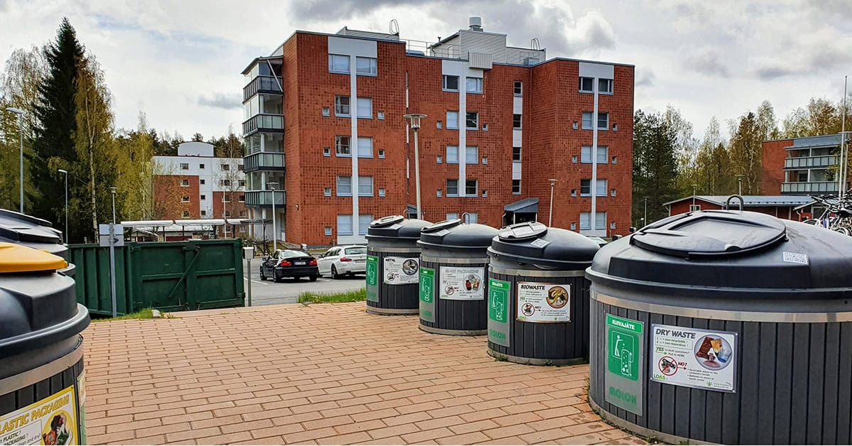 Kerrostalon pihaa, jossa eri jätejakeille syväkeräyssäiliöt.