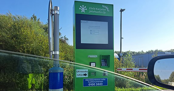 Auton ikkunasta otettu kuva Toikansuon Hyödyksi-aseman portin edessä olevasta itsepalveluautomaatista.