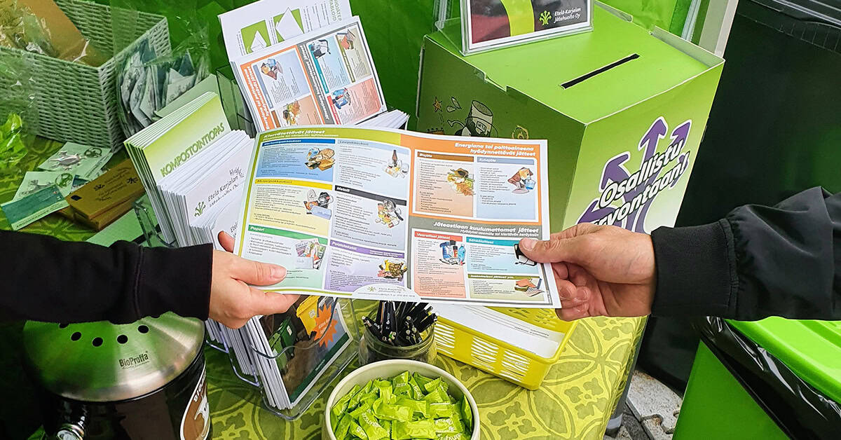 Punatiilinen toimistorakennus, jonka edessä vehreää puustoa ja lipputanko.