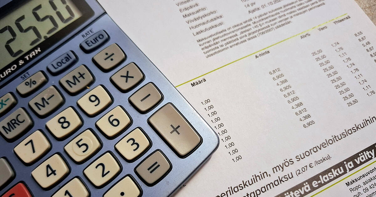 Näkymä omakotitalon pihatielle, vasemmassa laidassa valkoinen jätekatos, jonka räystäässä roikkuu kukka-amppeli.