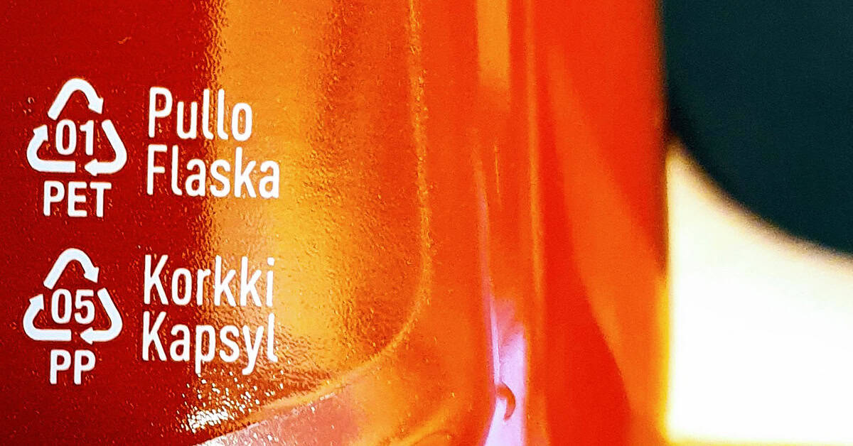 Punatiilinen toimistorakennus, jonka edessä vehreää puustoa ja lipputanko.