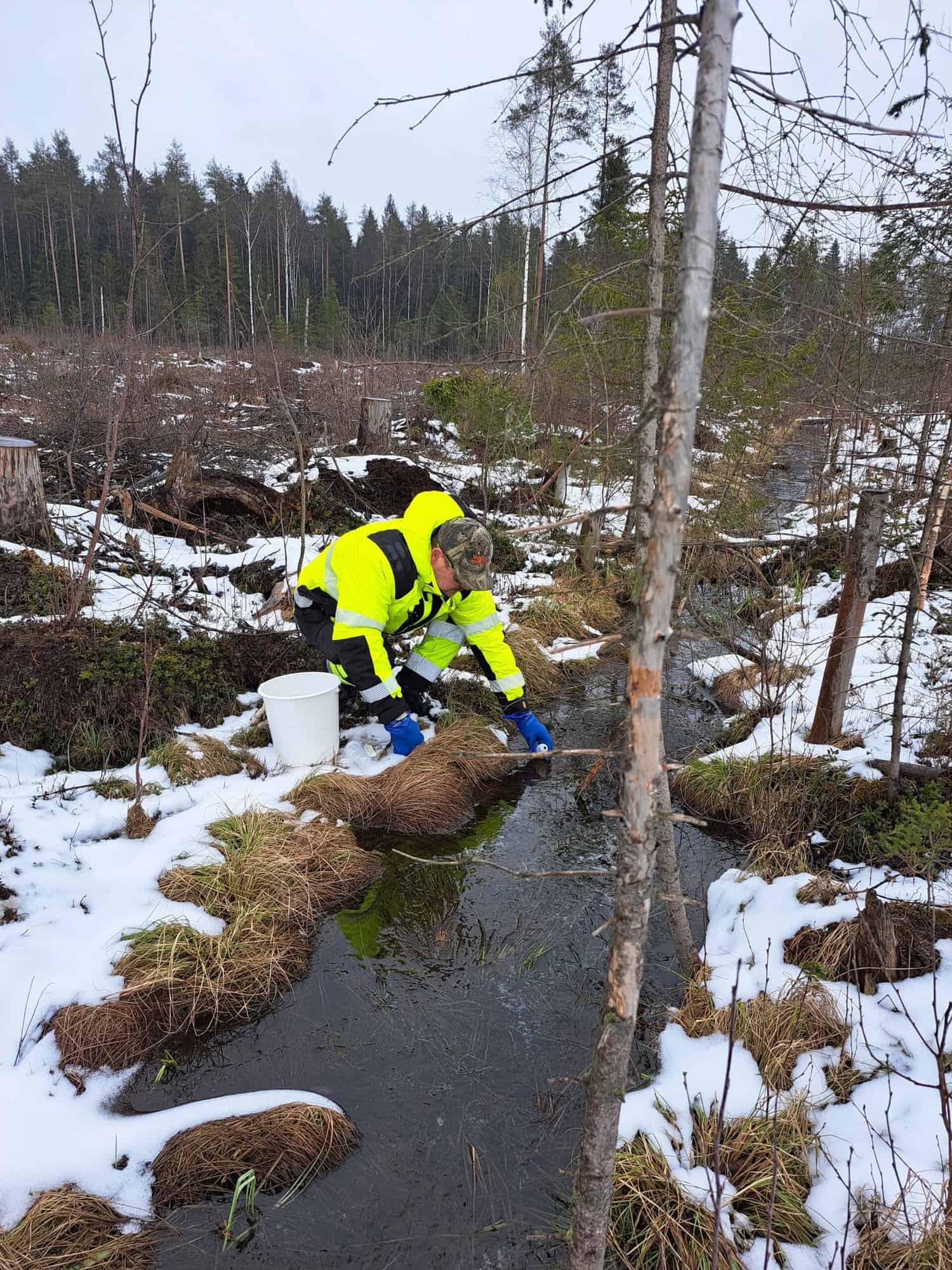 vesinäytteenottoa ojasta