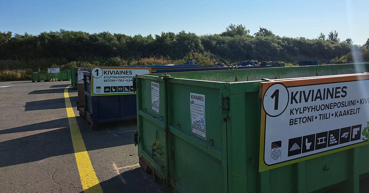 Hyödyksi-aseman vaihtolavoja Auton ikkunasta otettu kuva Toikansuon Hyödyksi-aseman portin edessä olevasta itsepalveluautomaatista.